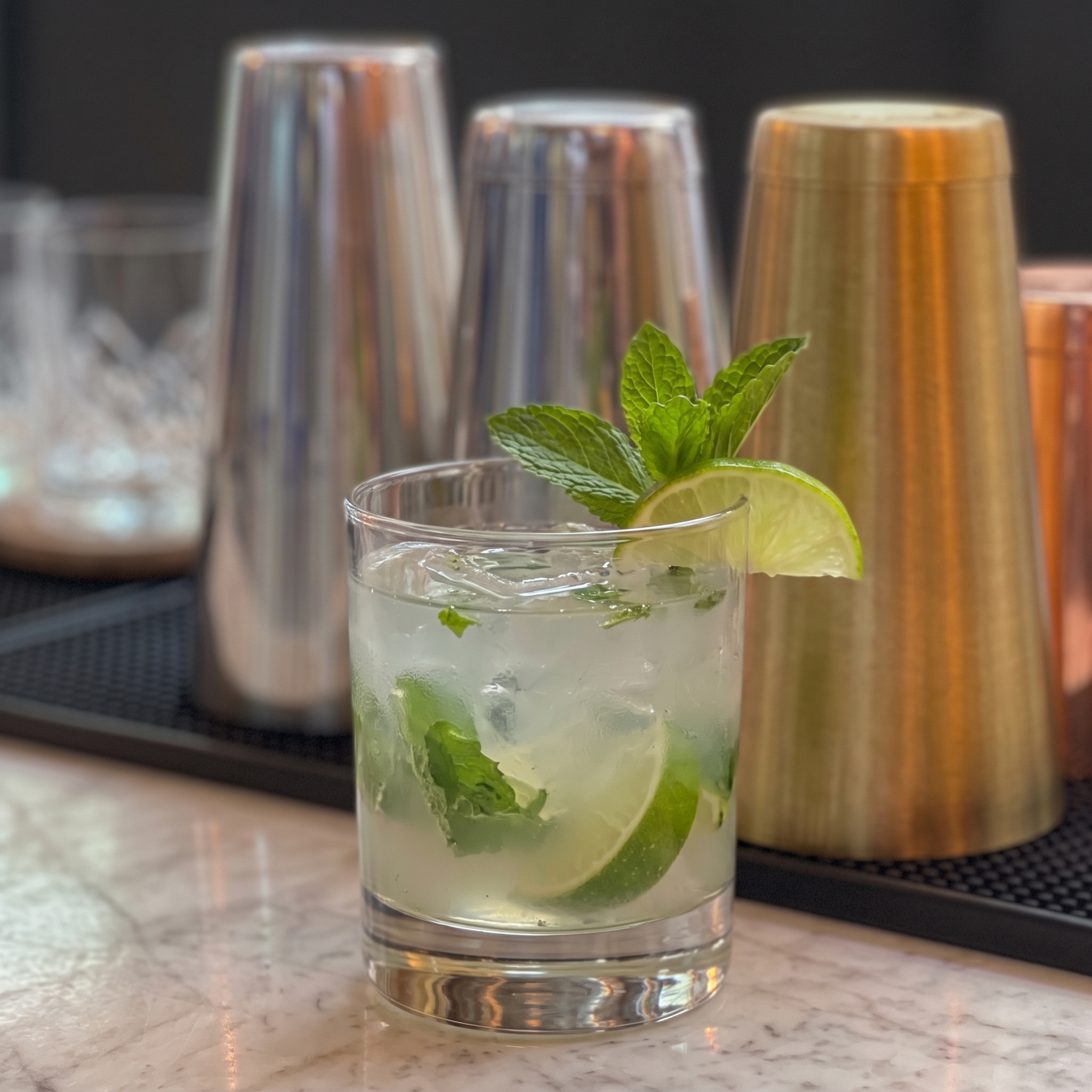 Vaso highball con Virgin Mojito, hojas de menta y una rodaja de lima.