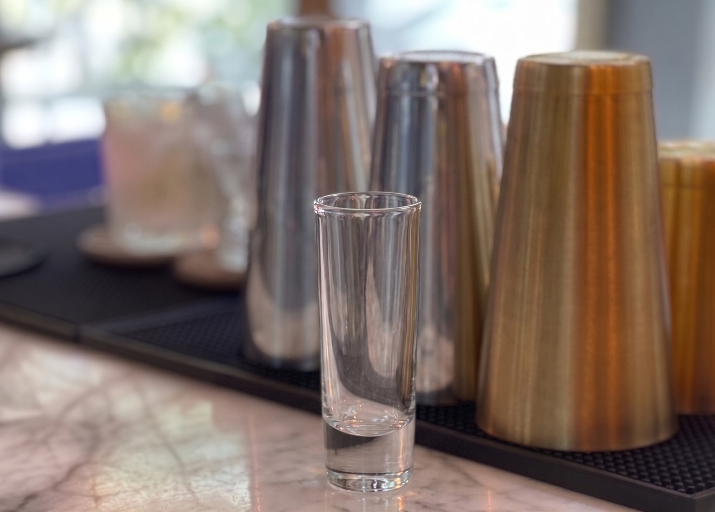 Vaso de chupito (caballito) vacío sobre una barra.